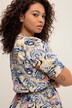 Robe midi à col en V et manches courtes. Ligne en A, motif imprimé et volant.