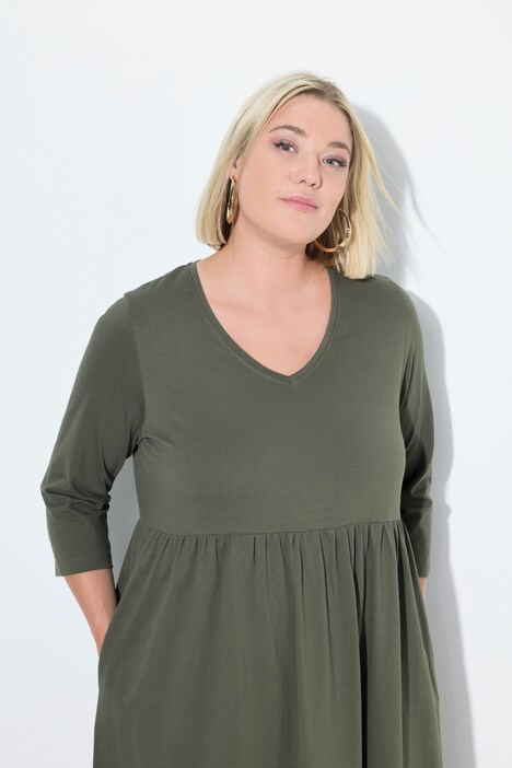 Robe en jersey, couture empire. Décolleté en V et manches 3/4. Poches
