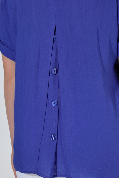 Blouse à manches courtes, boutons dans le dos et pli fantaisie. Coupe oversize.