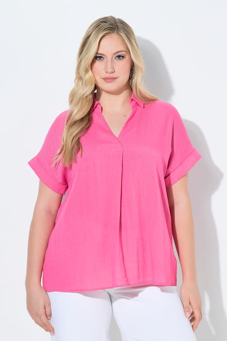 Blouse à manches courtes, boutons dans le dos et pli fantaisie. Coupe oversize.