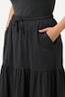 Jupe en jersey texturé. Coupe évasée et volant. Taille élastique