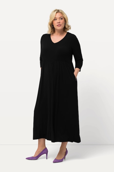 Robe en jersey coupe trapèze, avec décolleté en V et manches 3/4. Poches