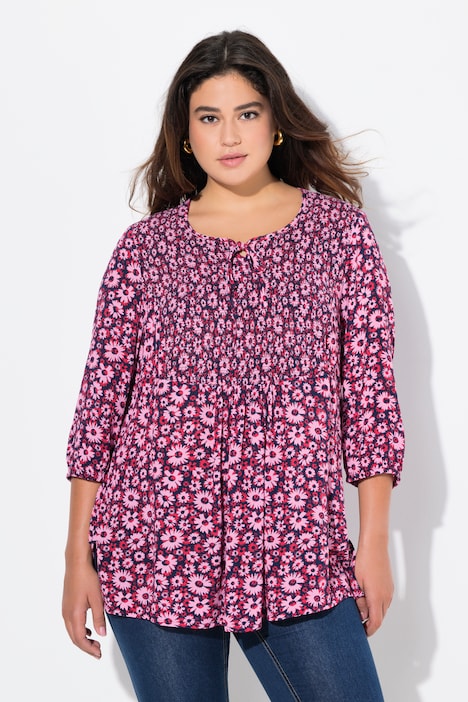 Blouse smockée, motif à fleurs. Décolleté rond et manches 3/4. Cordon